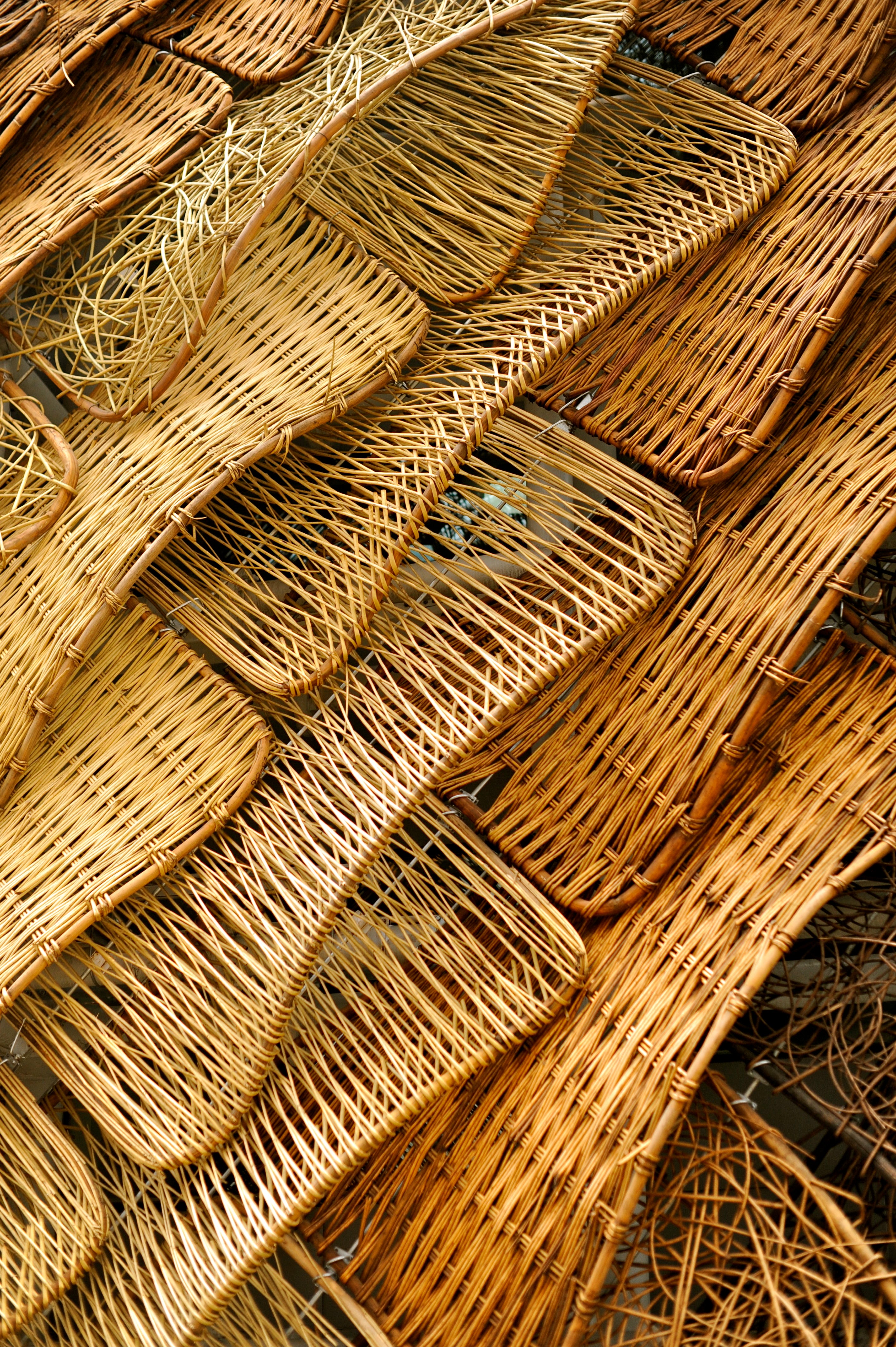 The exterior surface is made of basket material of various configurations shingled to create a loose, rich pattern.