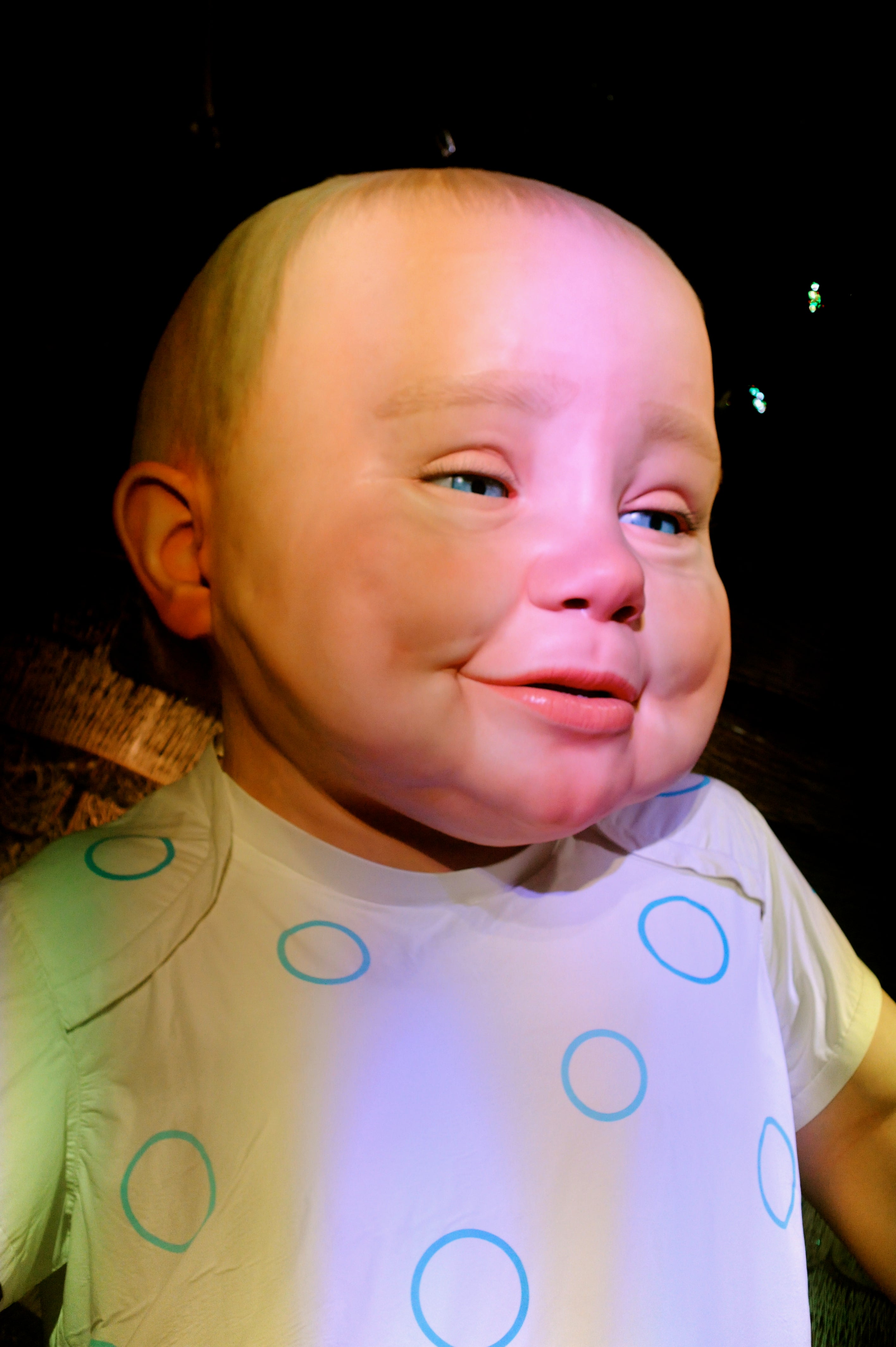 The baby is amazingly lifelike.  It changes expressions and moves very slowly in response to the crowd.  If one area gets particularly loud it will look over in that direction.