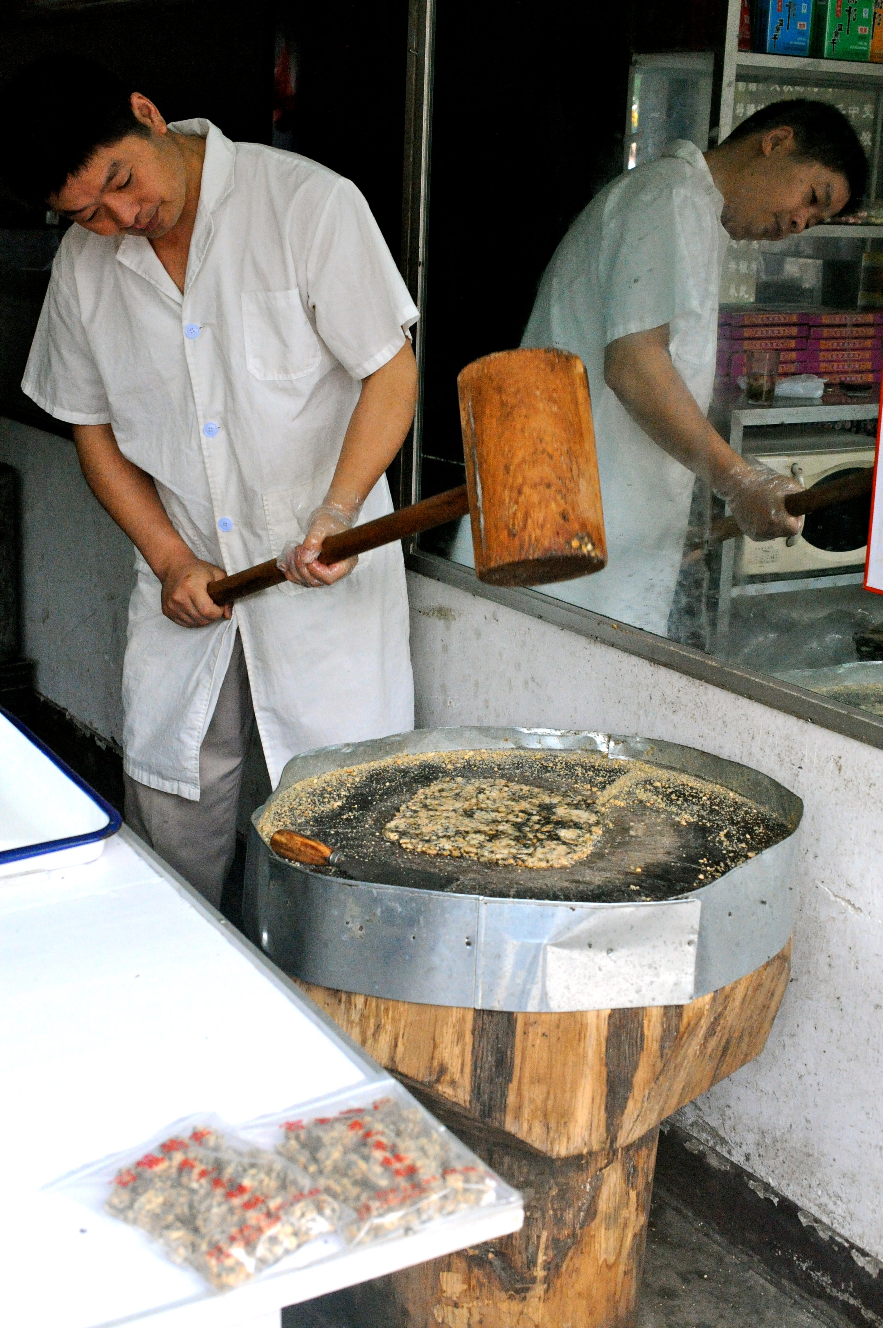 Candy maker pulverizing nuts.