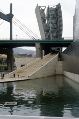 Guggenheim Art Museum in Bilbao Spain by Architect Frank Gehry, photographed by Larry Speck. View from La Salve Zubia bridge before renovation, no red arch yet.