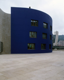 Guggenheim Art Museum in Bilbao Spain by Architect Frank Gehry, photographed by Larry Speck. Exterior, back, behind, limestone siding.